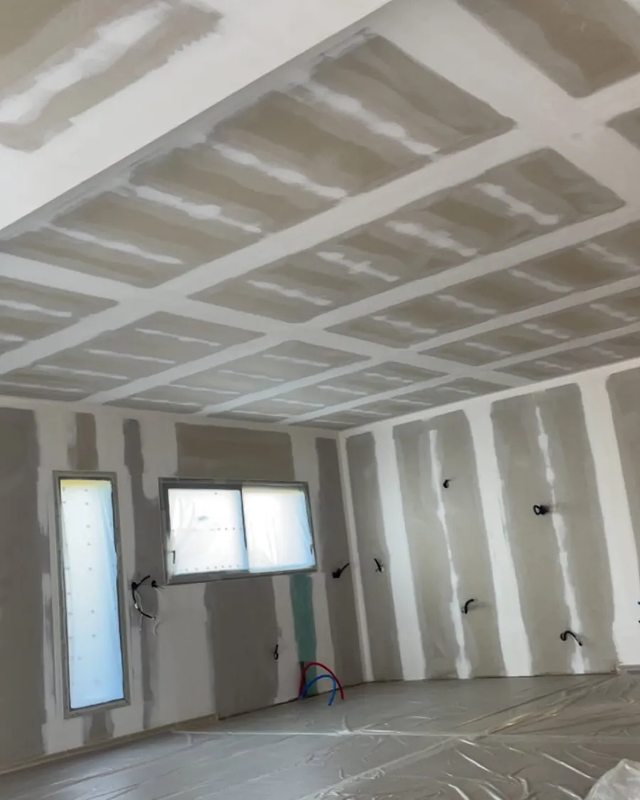 Maison neuve : plaques de plâtre bandées, sol protégé avant peinture