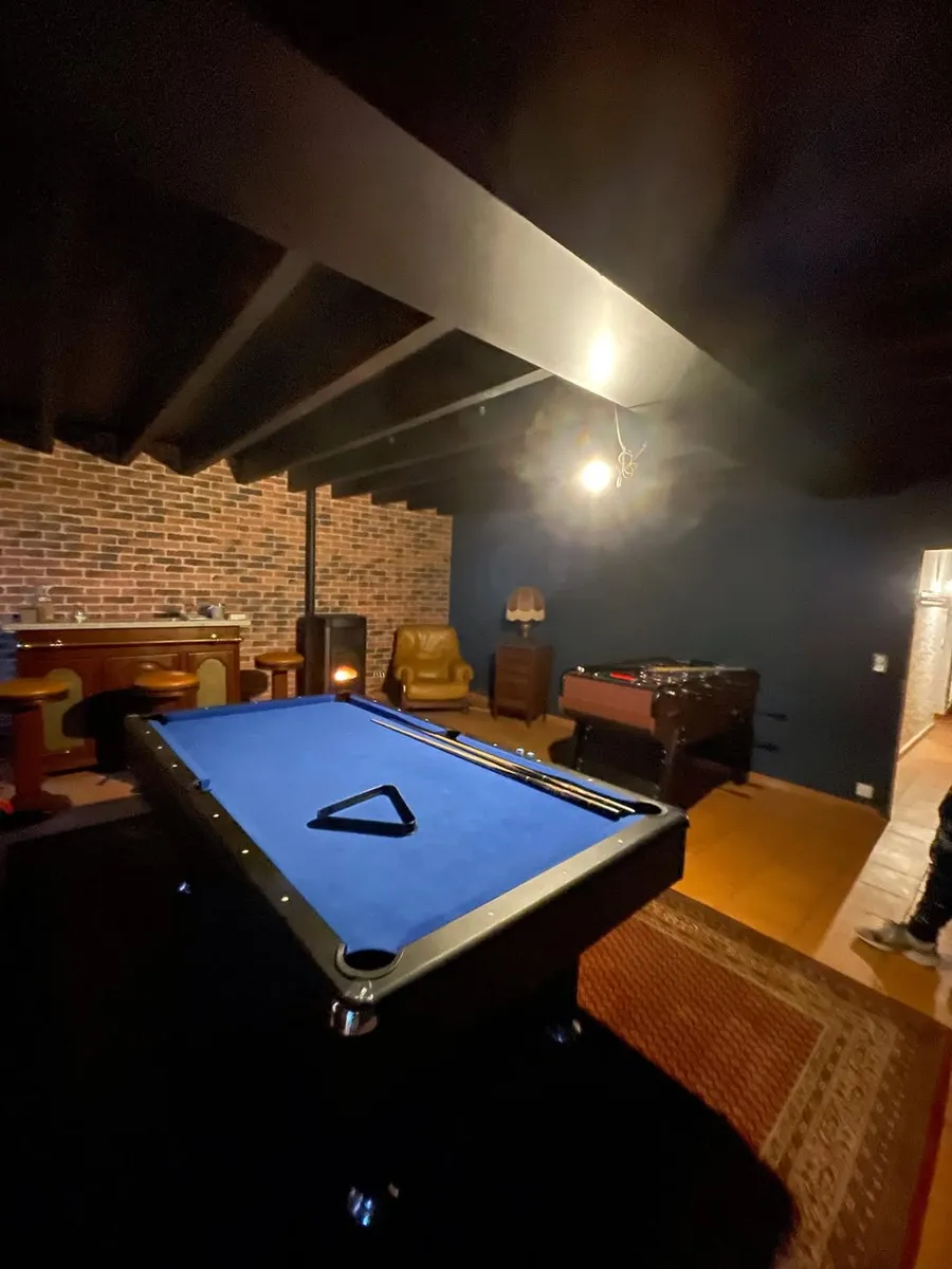 Salle de jeux aux murs bleu nuit avec billard